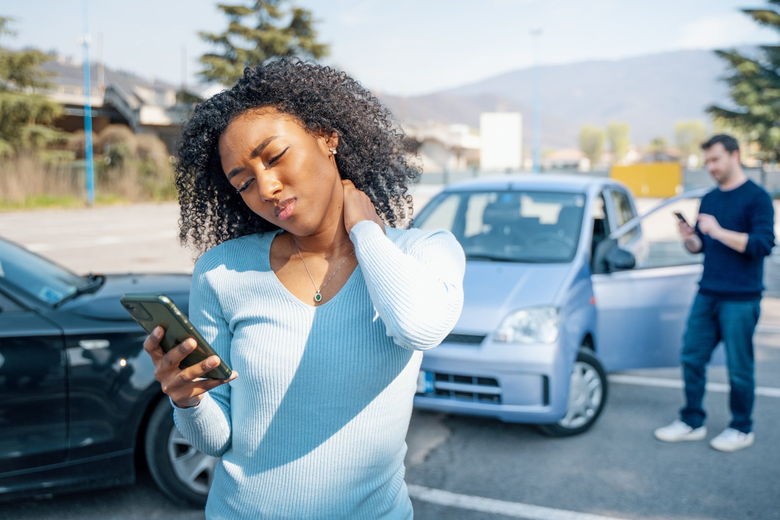 rideshare app on smartphone with accident in background