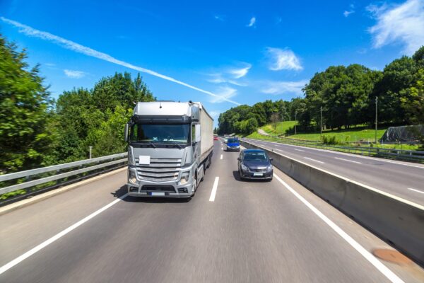 Side-by-side visual of a large semi-truck next to a small passenger car, highlighting size difference Comparison of a commercial truck and passenger car showing size difference and accident impact risk