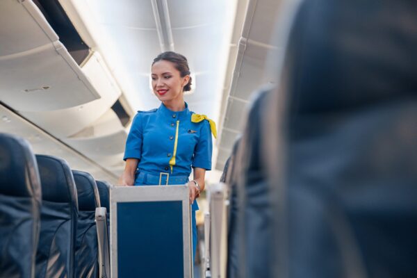 Passengers seated on a plane, with a flight attendant pushing a service cart down the aisle Who is responsible for injuries on a plane shown through in-flight accident risks