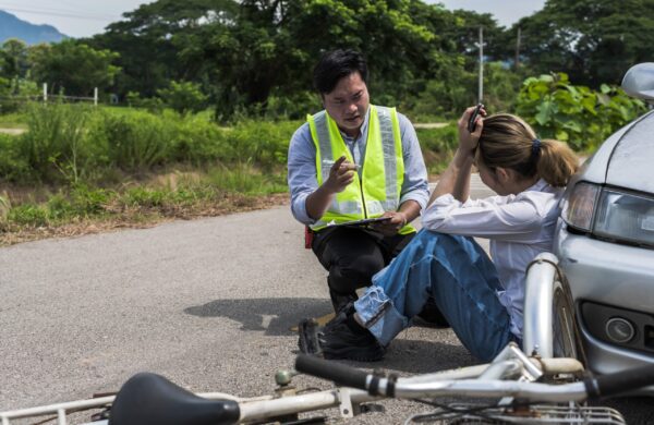 Bicycle on roadside with officer taking notes legal tips for injured cyclists crash documentation
