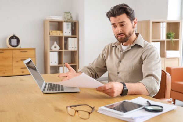 Damaged product on a table with a person reviewing legal documents beside it when to sue for a defective product injury Pyramid Legal