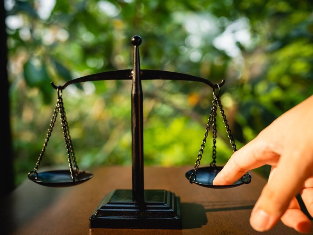 Scale of justice illustrating how comparative negligence impacts motorcycle helmet injury claims compensation.