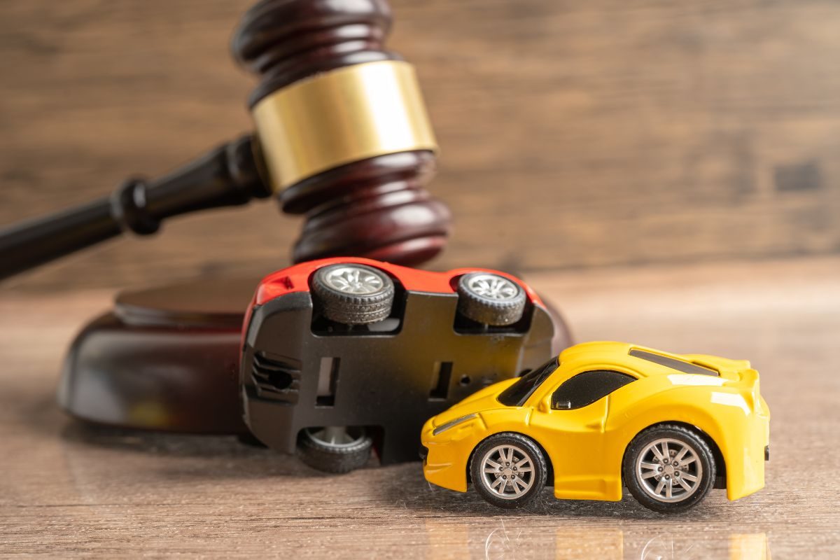 Toy cars and gavel symbolize legal justice for car accidents on wooden background.