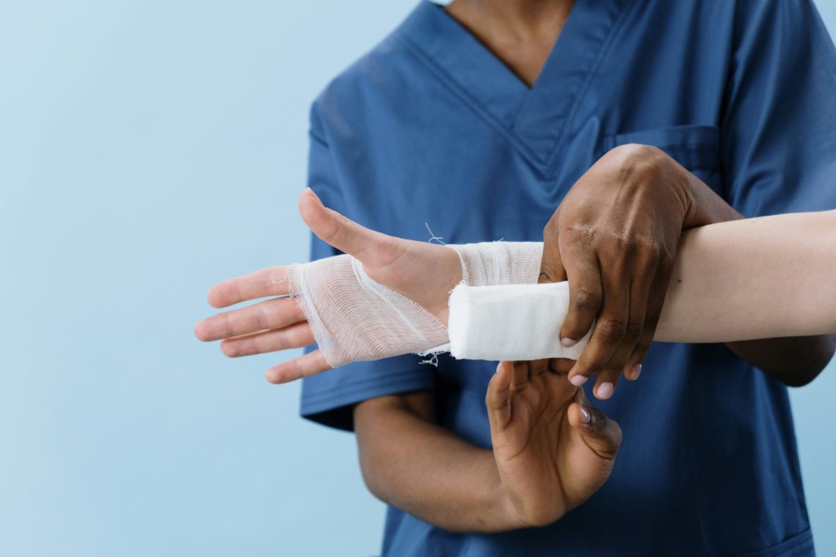 Healthcare professional applying a bandage to a patient's wrist, close-up view.