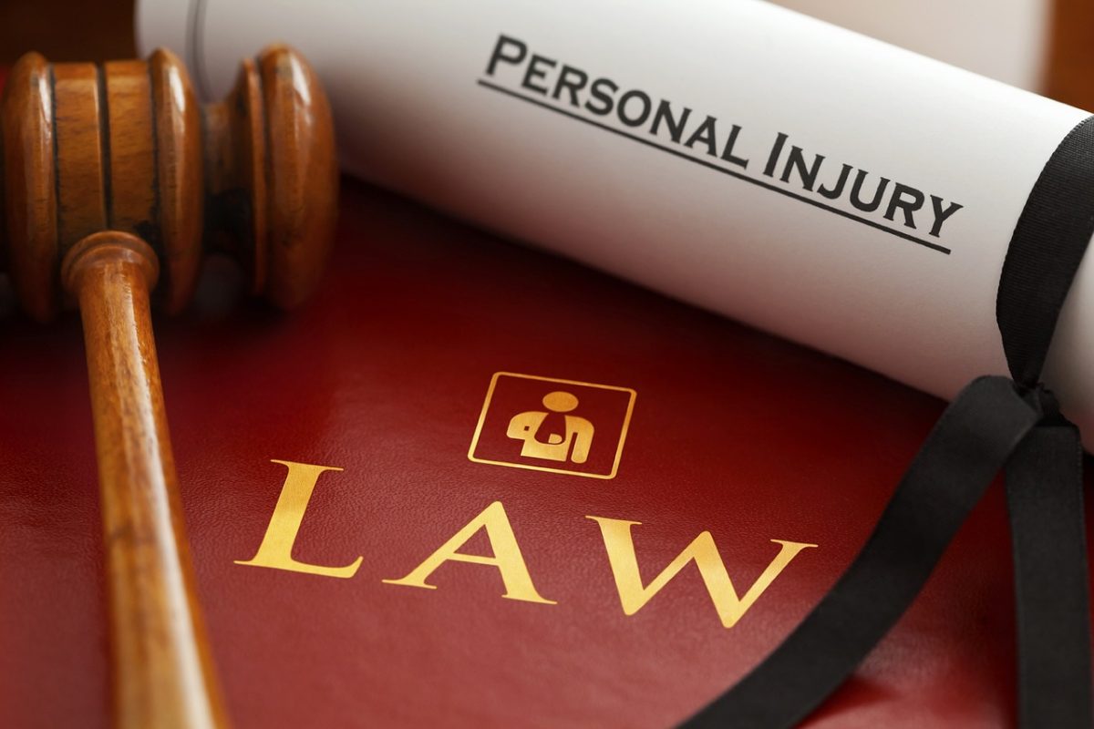 Gavel on red legal book with Law text and personal injury document, symbolizing legal representation.