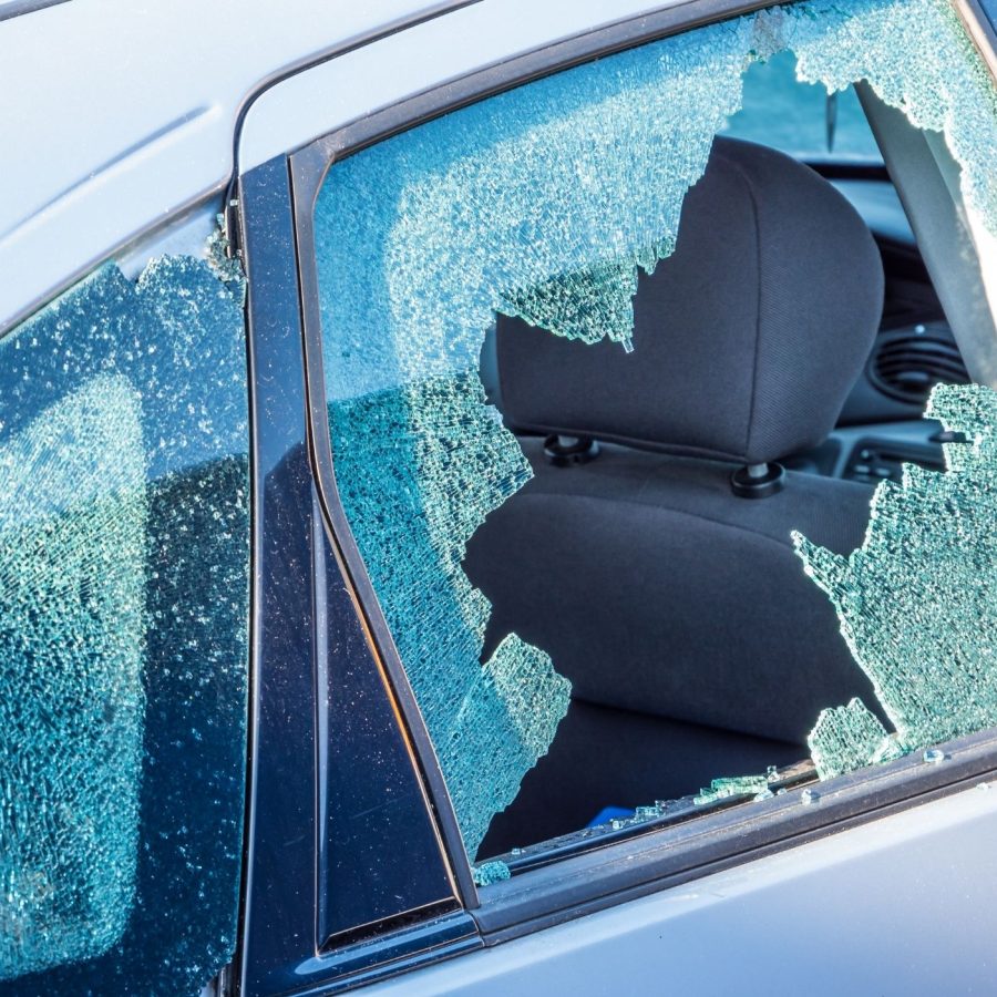 Broken car window with shattered glass on vehicle's rear door.