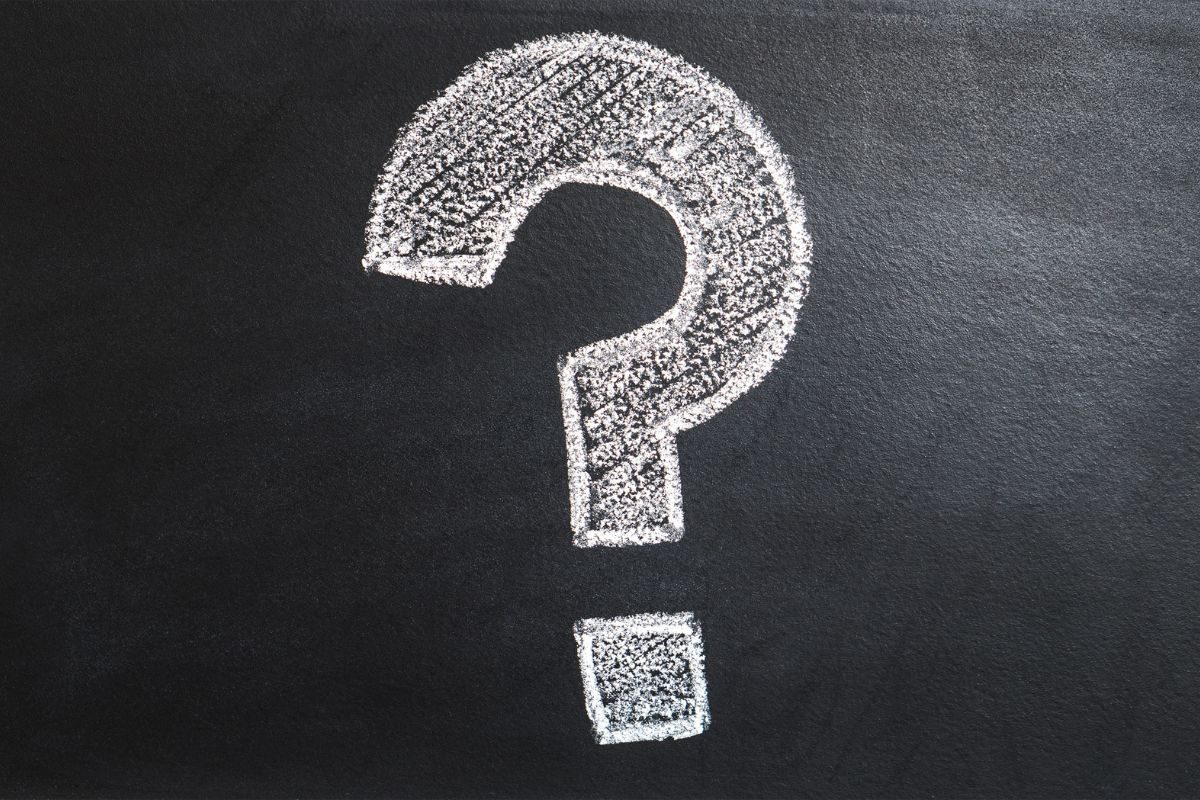 Chalk question mark on a blackboard background, symbolizing inquiry and curiosity in education.