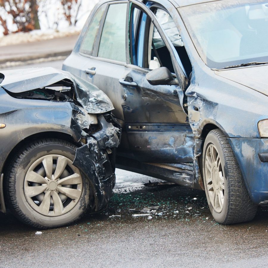 Two cars damaged in a side collision on a city street.