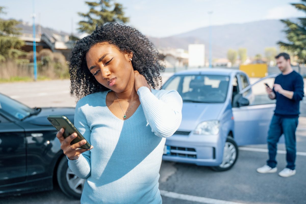 rideshare app on smartphone with accident in background